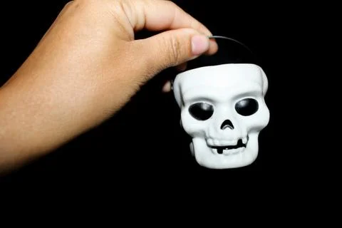 White hand holding a white skull Stock Photos