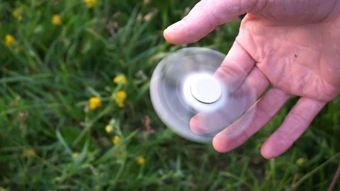 White hand spinner, or fidgeting spinner, rotating on child's hand 库存影片 76972126