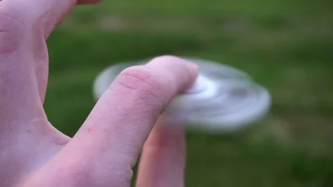 White hand spinner, or fidgeting spinner, rotating on child's hand Stock Footage 76972584
