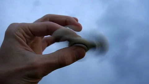 White hand spinner, or fidgeting spinner, rotating on child's hand Stock Footage 76972663