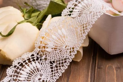 White handiwork lace on the table among roses White handiwork lace lying o... Stock Photos