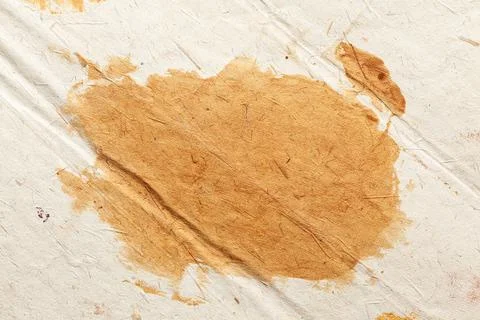 White handmade rough paper with multiple golden yellow colored stains Stock Photos