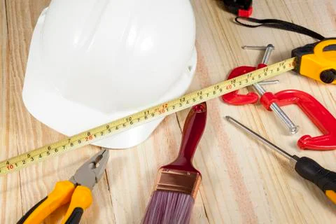 White hard hat and tools laying on a wodden floor Foto stock