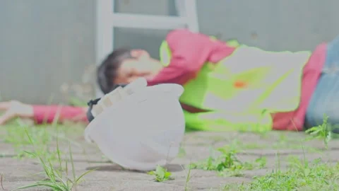 White hard hat lying on ground with construction worker blurred in background Stock Footage 337121941