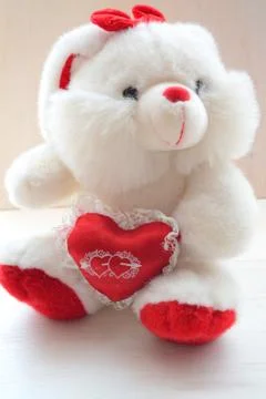 White hare toy on white background with red heart. Holiday card. White rabbit Stock Photos
