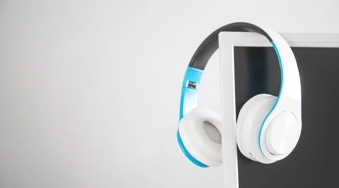 White headphones with a computer screen. Stock Photos
