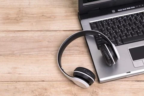 White headphones placed on a computer laptop on the table Stock Photos