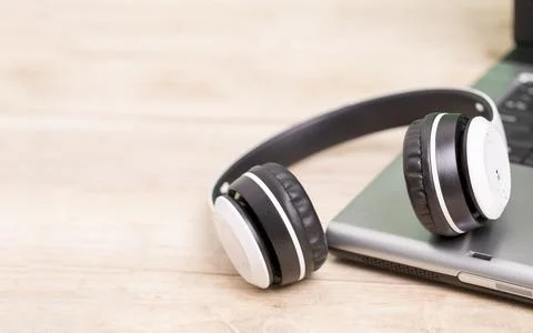 White headphones placed on a computer laptop on the table Stock Photos