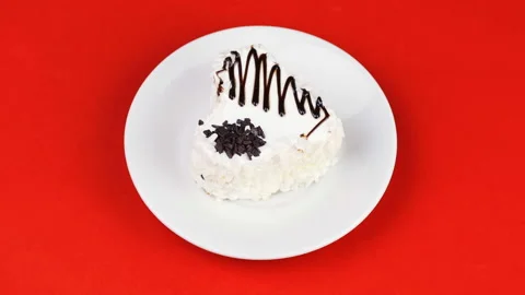 White heart cake with chocolate icing on a red background. Stock Footage 101674463