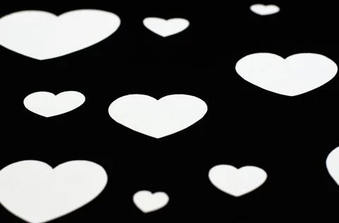 White hearts of different sizes on a black background Stock Photos