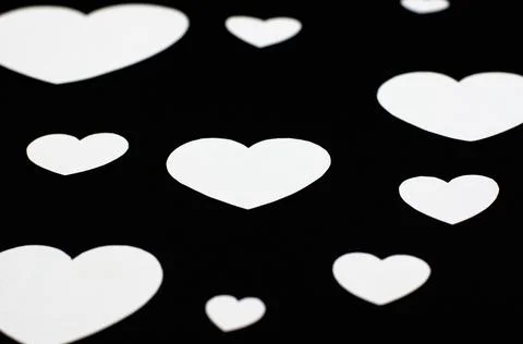 White hearts of different sizes on a black background Stock Photos