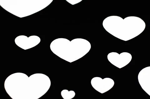 White hearts of different sizes on a black background Stock Photos