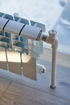 White heating radiator in front of a large window Stock Photos