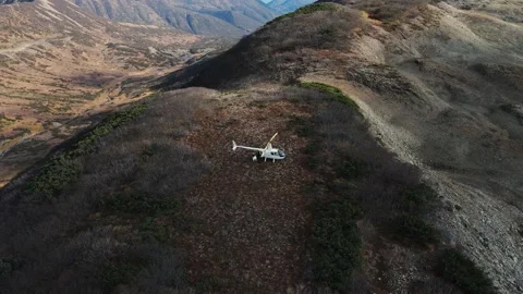 A white helicopter is up in the mountains. Stock Footage 280379081