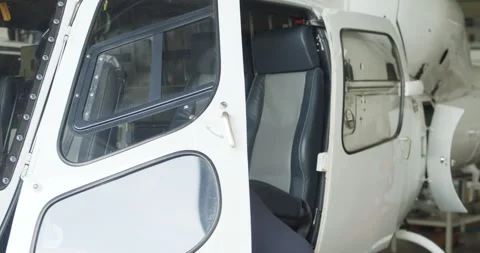 White helicopter with open doors. Technician performing basic maintenance in Video stock 249699466