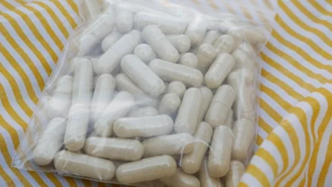White herbal supplement capsules in clear ziplock 库存影片 330764193