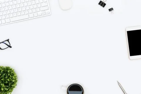 White hipster desk table with computer gadgets and supplies. Top view with co Stock Photos