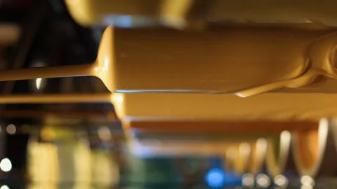 White hot liquid chocolate flows in machine in a factory slow mo vertical video Vidéo 252384232