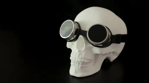 White human skull with steampunk goggles on a black background Stock Footage 292651159
