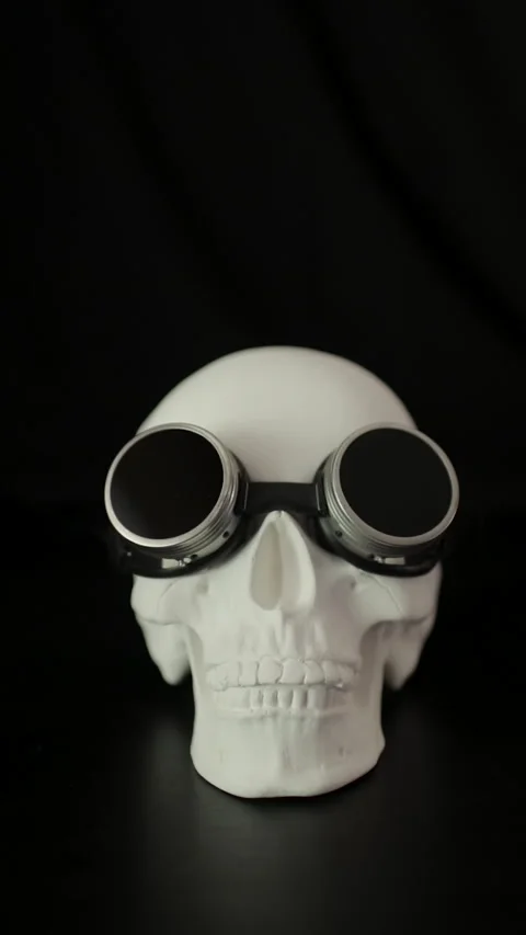 White human skull with steampunk goggles on a black background. Vertical video. Vídeos de archivo 293786381