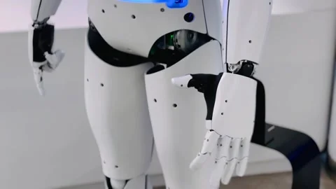 White humanoid robot with moving hands in an industrial setting for stock photo Stock Footage 323352201