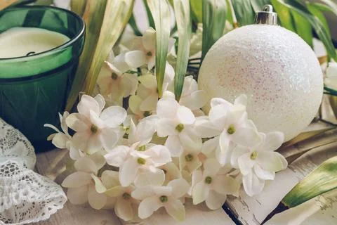 White hydrangea flowers, palm leaf, candle, lace  and christmas ball decor as Stock Photos