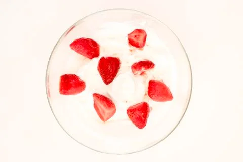 White ice cream with strawberries split in half in transparent plate on white Stock Photos
