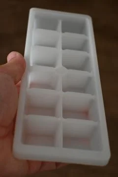 White ice cube tray held in hand Stock Photos