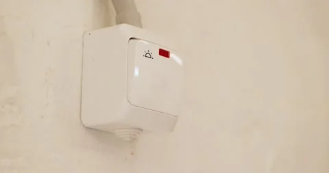 White indoor garage light switch being turned on and off Stock Footage 346096314