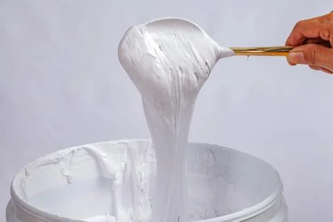 White ink dripping from spoon Stock Photos