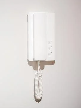 A white intercom on a wall, close-up. Stock Photos