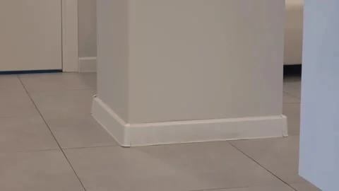 White interior corner showcasing a column with a baseboard and tiled floor, Stock Footage 331248984
