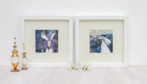 White interior display. Two framed hare paintings, blue backgrounds. Stock-Fotos