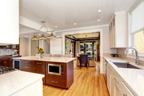 White interior of kitchen room with large kitchen island, modern pendant ligh Stock Photos