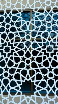 White islamic star pattern overlays blue window frames creating geometric sym Stock Photos