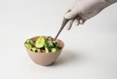 On a white isolated background prepared vegetable salad in a bowl. A woman's Stock Photos