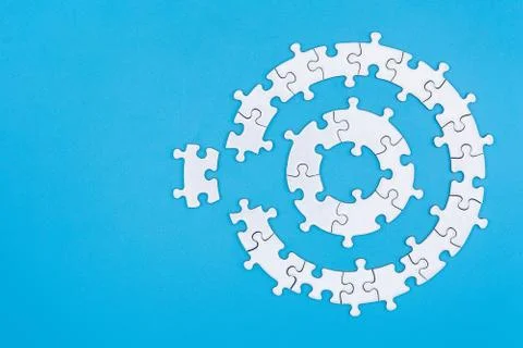 White jigsaw pieces on a blue background, Copy space, Concept image of unfini Stock Photos