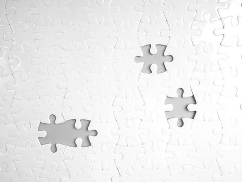 White jigsaw puzzle background with missing pieces creating visible gaps. I.. Fotos de archivo