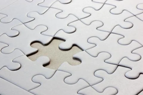 White jigsaw puzzle with a missing piece Stock Photos