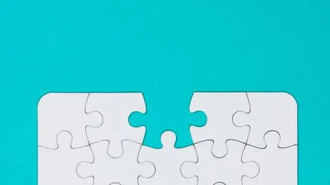 White jigsaw puzzle with a missing piece - blue background Stock Photos