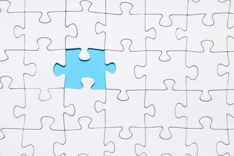 White jigsaw puzzle with missing piece on blue background Stock Photos