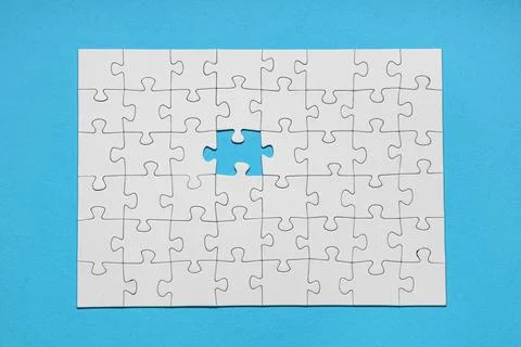 White jigsaw puzzle with missing piece on blue background Stock Photos