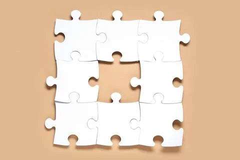 White jigsaw puzzle with missing piece on beige background Stock Photos