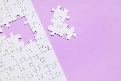 White jigsaw puzzle with missing pieces on purple background Stock Photos