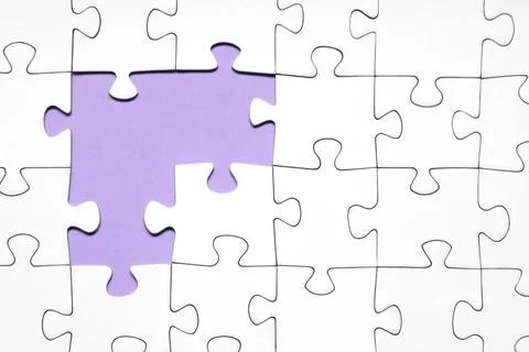 White jigsaw puzzle with missing pieces on purple background Stock Photos