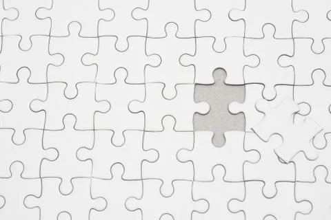 White jigsaw puzzle pattern background. placing last piece of jigsaw puzzle Stock Photos