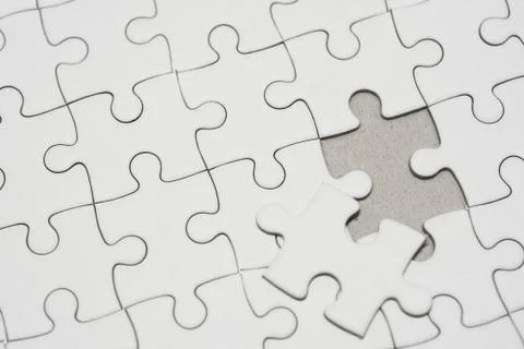 White jigsaw puzzle pattern background. placing last piece of jigsaw puzzle Stock Photos