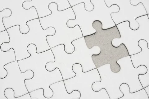 White jigsaw puzzle pattern background. placing last piece of jigsaw puzzle Stock Photos