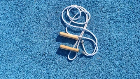 White Jump rope On blue rubberized surface Stock Footage 323294714