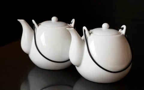 White kettles or tea pots on black background Stock Photos
